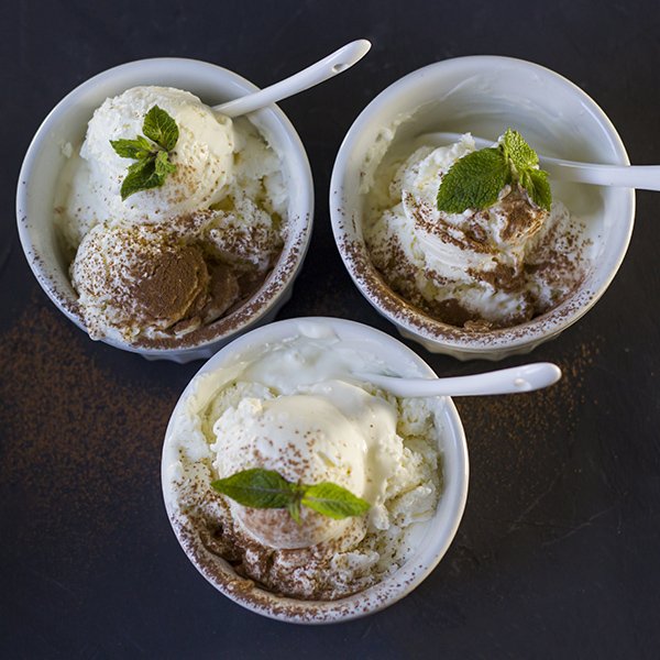 Background of three balls of ice cream in cups. Three servings of ice cream. Fresh ice cream for dessert. Mint and chocolate. View from above. copyspace