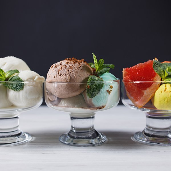 Set of ice cream scoops of different colors and flavors in glass sundae bowls. Summer delicious food, tasty refreshing dessert