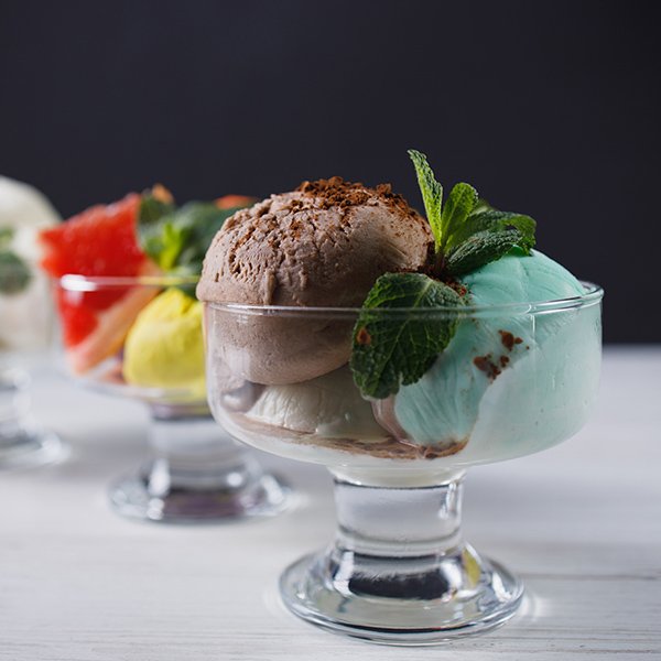 Set of ice cream scoops of different colors and flavors in glass sundae bowls. Summer delicious food, tasty refreshing dessert